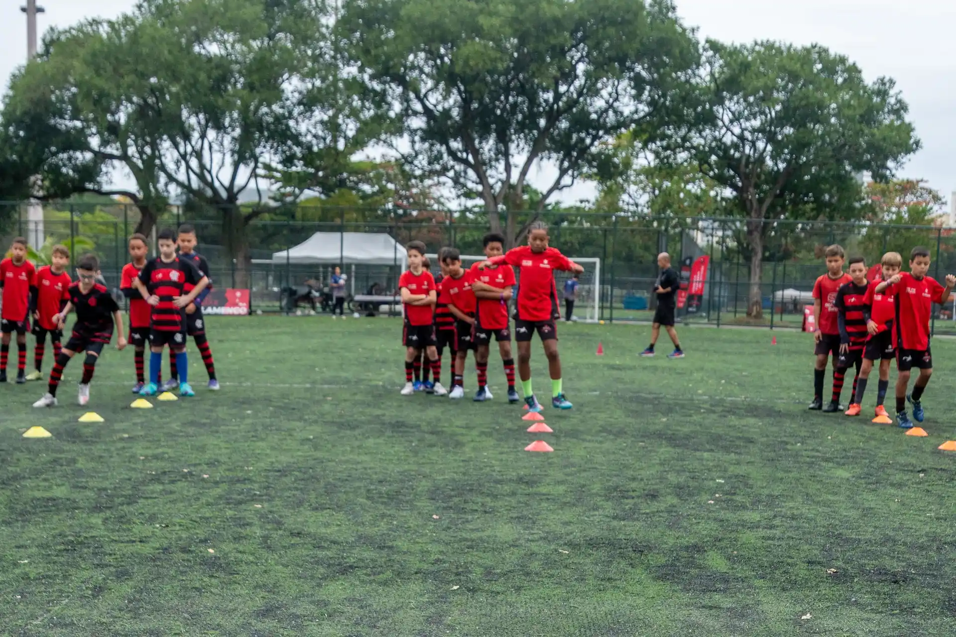 Atletas do Flamengo Escola de Futebol espalhados pelo campo durante treino de circuito